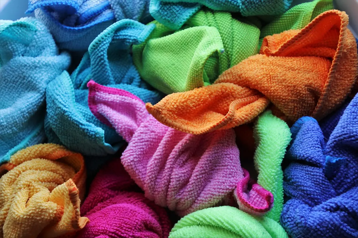 Fenêtre propre avec raclette et chiffon microfibre posés près d'un encadrement